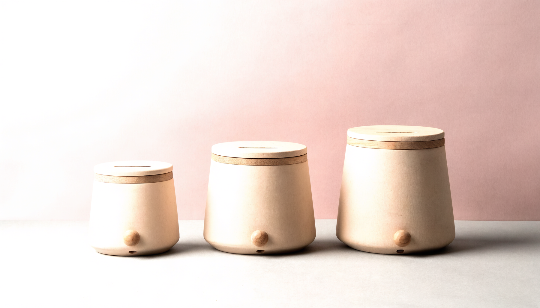 Trois tirelires de tailles croissantes, avec leur fente et leur trappe